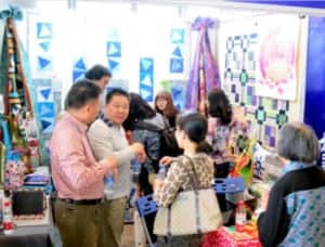 Visitors in the quilting show booth