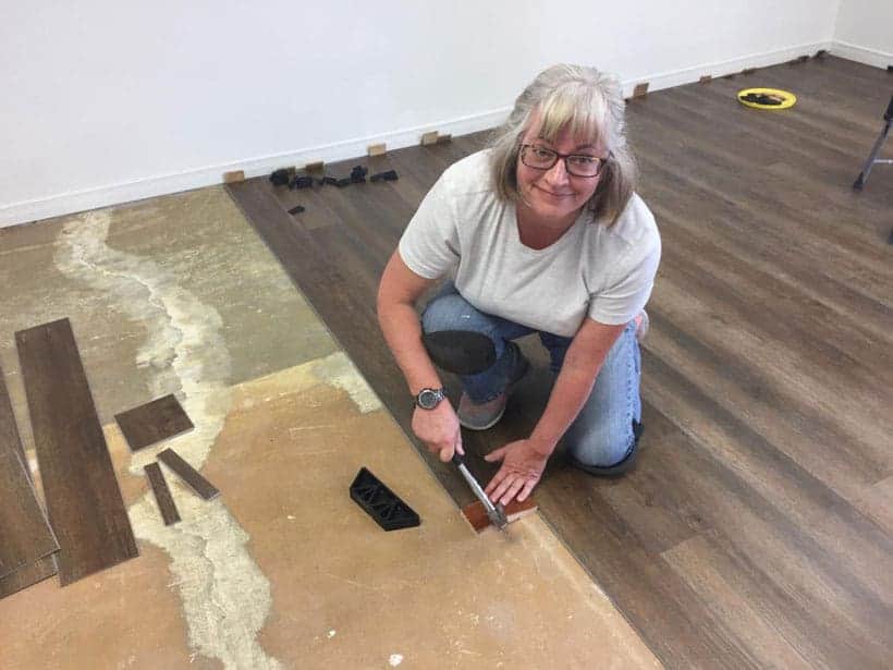 Brenda installing flooring inside the studio