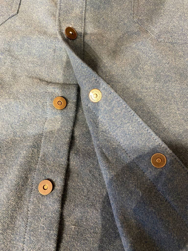 Magnets with mock buttons on a men's shirt that make getting dressed easier for those with amputations or arthritic fingers.