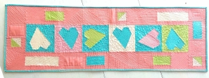 Engaged by Love paper pieced table runner sample features fabrics from the Northcott ColorWorks Collection.